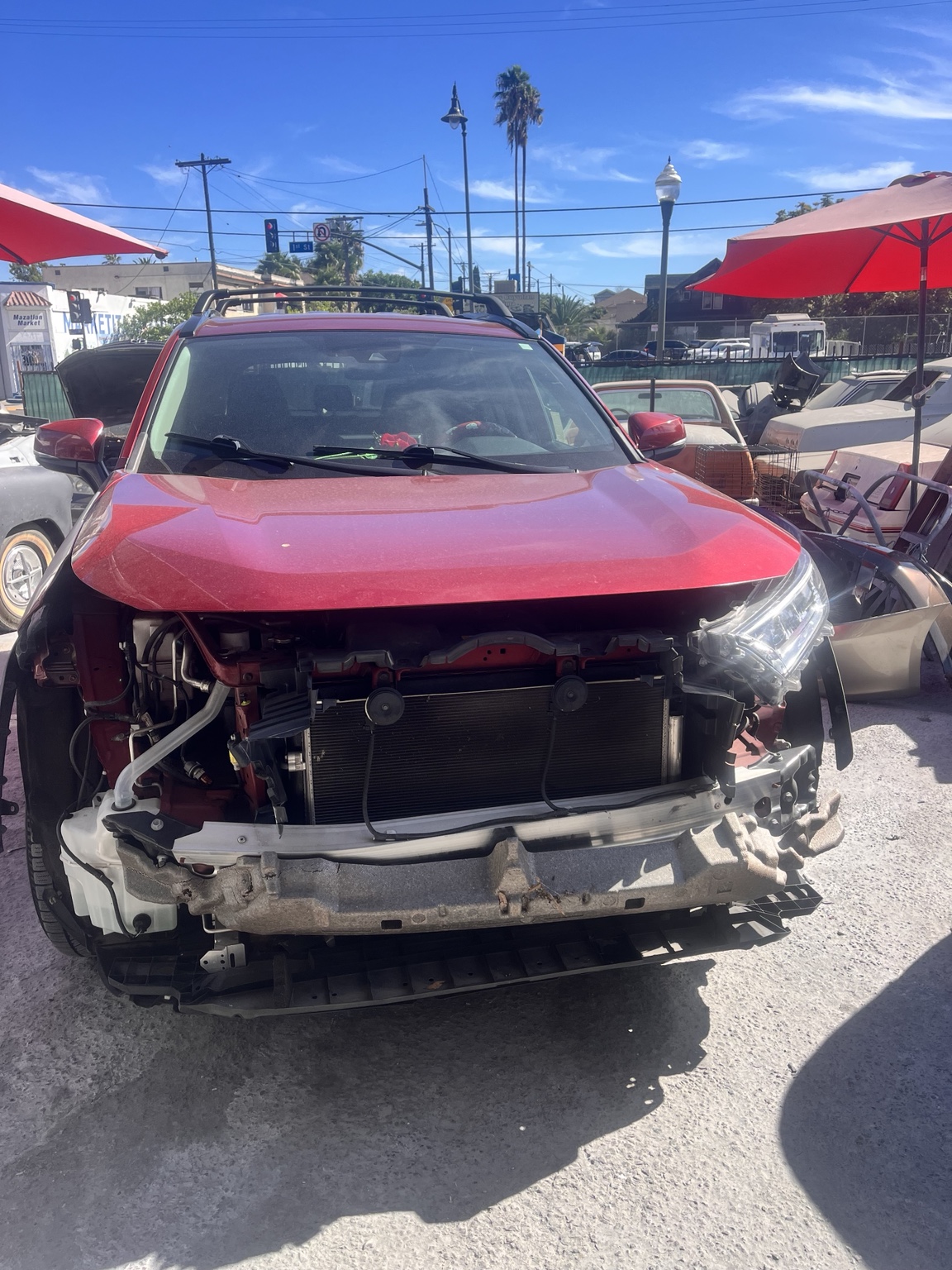 Same Toyota RAV4 with damaged and removed front-end components before repair
